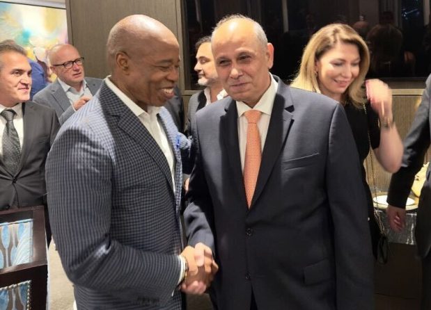 Photo shows Mayor Eric Adams shaking hands with Ali Kocak, president of the Turkish American Chamber of Commerce and Industry. Over Kocak's shoulder is Rana Abbasova, Adams' former director of protocol in International Affairs Office. (LinkedIn)