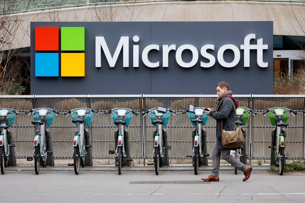 A pedestrian walks past the logo of the U.S. tech giant Microsoft.