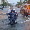 Victor Corone, 66, pushes his wife Maria Diaz, 64, in a wheelchair through more than a foot of floodwater in Miami Beach, Fla., on Wednesday, June 12, 2024. The annual rainy season has arrived with a wallop in much of Florida.