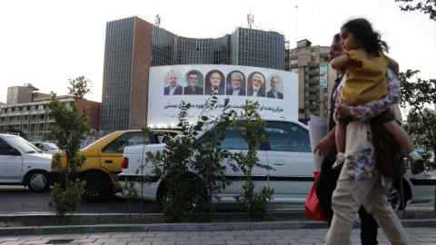 A billboard with a picture of the presidential candidates is displayed on a street in Tehran